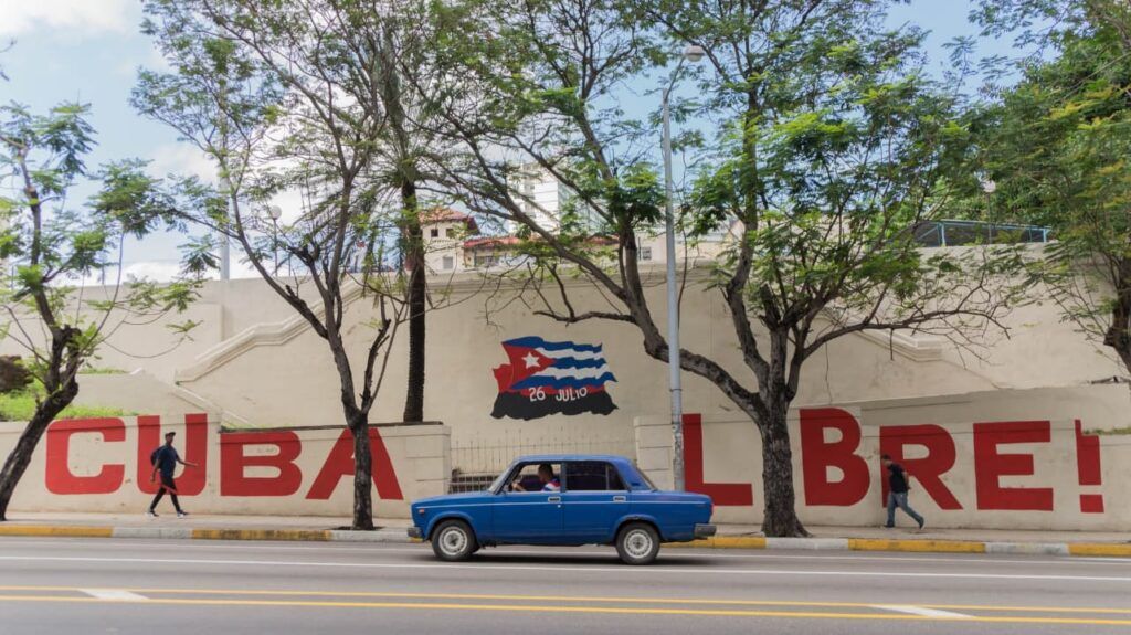 Une voiture cubaine typique devant une fresque murale