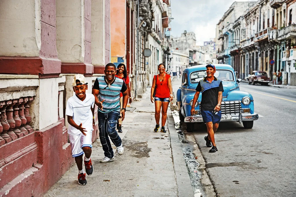 Des gens souriants sur un trottoir à Cuba