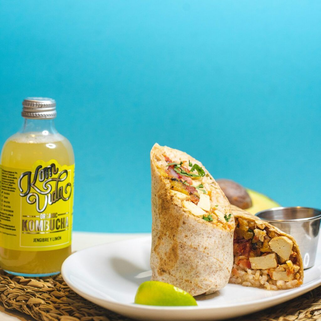 Une bouteille de kombucha bio Komvida au gingembre et au citron et quelques tacos