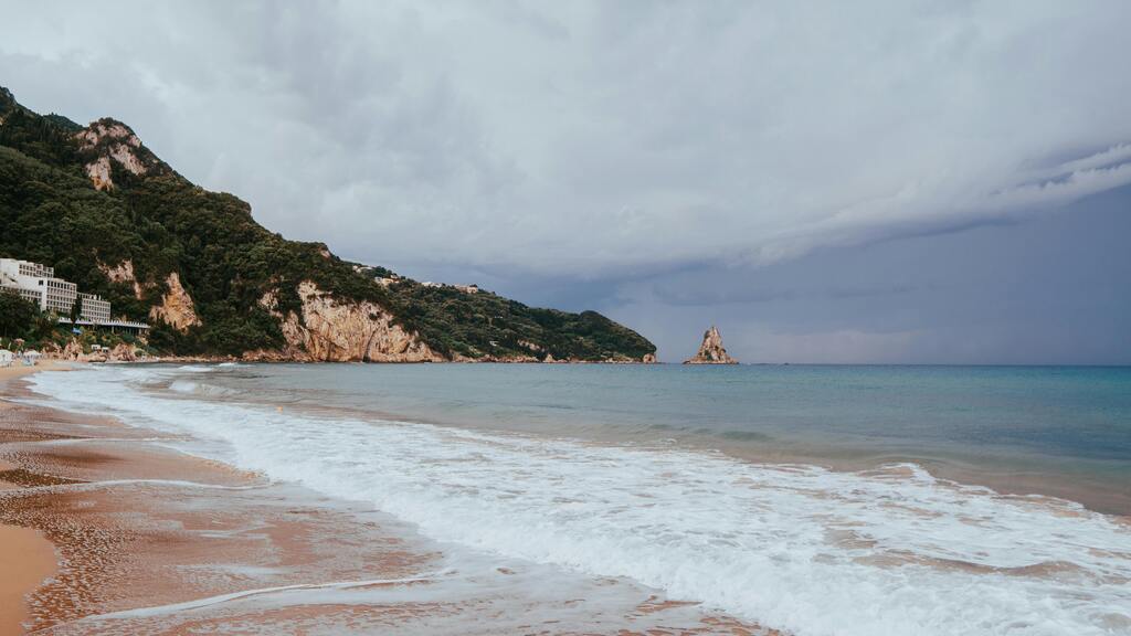 Plage sauvage et vagues sous un ciel orageux à Corfou, Grèce.
