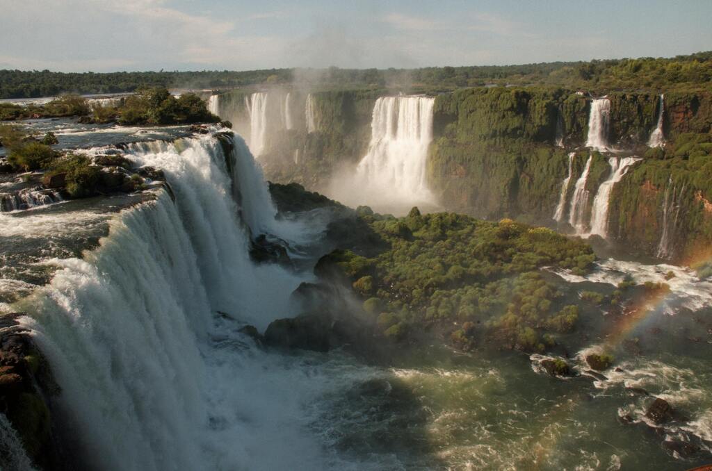 Les chutes d'Iguazú: vue panoramique des célèbres chutes d'eau entre l'Argentine et le Brésil avec un arc-en-ciel en arrière-plan.