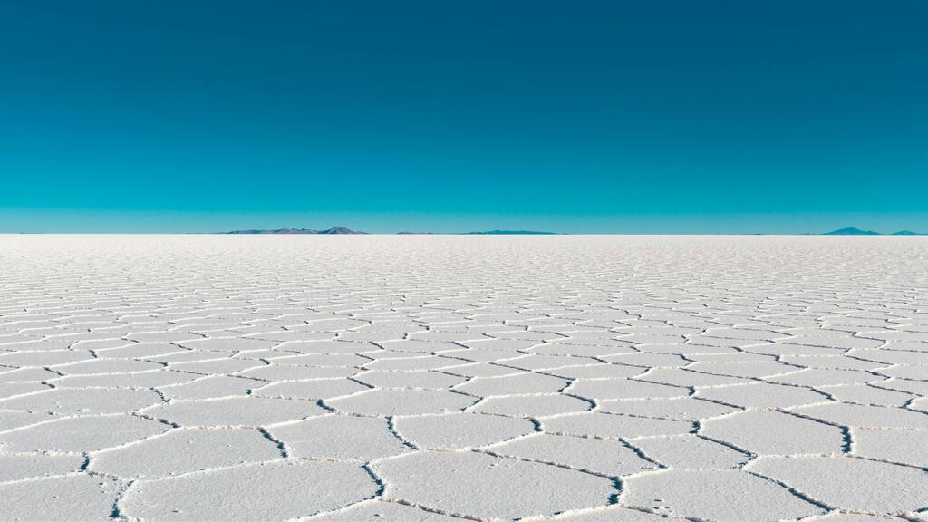 Étendue infinie du Salar de Uyuni avec motif hexagonal sur le sel blanc