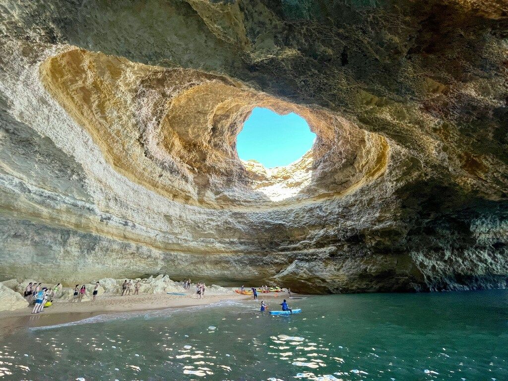 La grotte marine de Benagil avec sa célèbre ouverture circulaire dans le plafond, baignée de lumière naturelle.