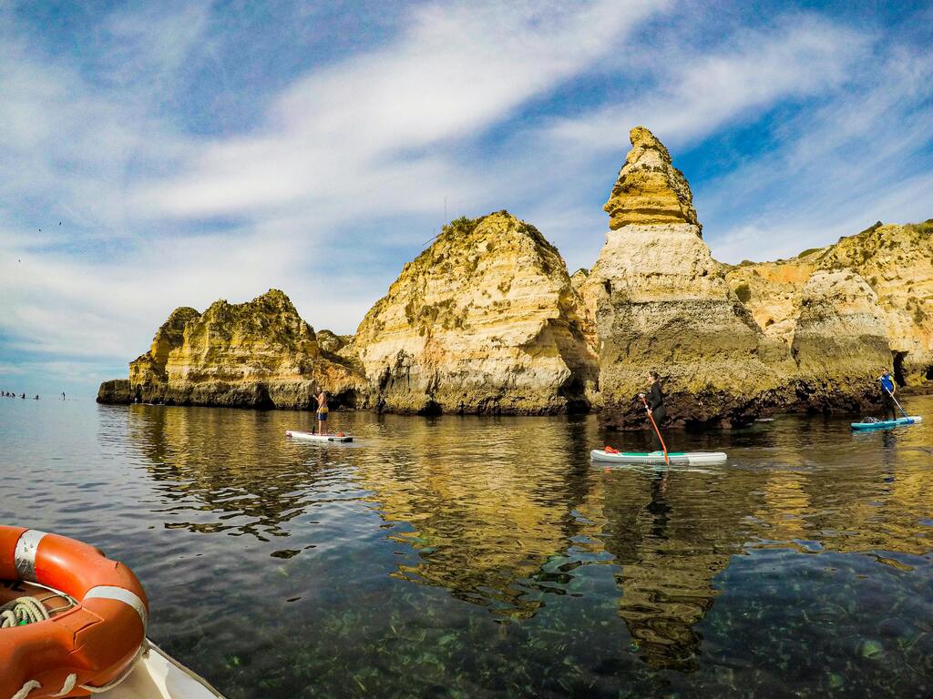 Personnes faisant du paddle entre les formations rocheuses emblématiques de l’Algarve, au Portugal.