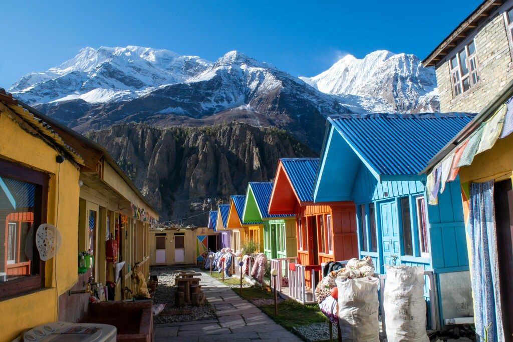 Maisons colorées au pied des montagnes enneigées au Népal