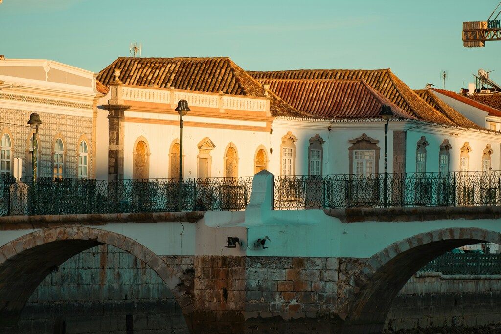 Maisons blanches traditionnelles et pont historique au coucher du soleil dans la ville de Tavira, au sud du Portugal.