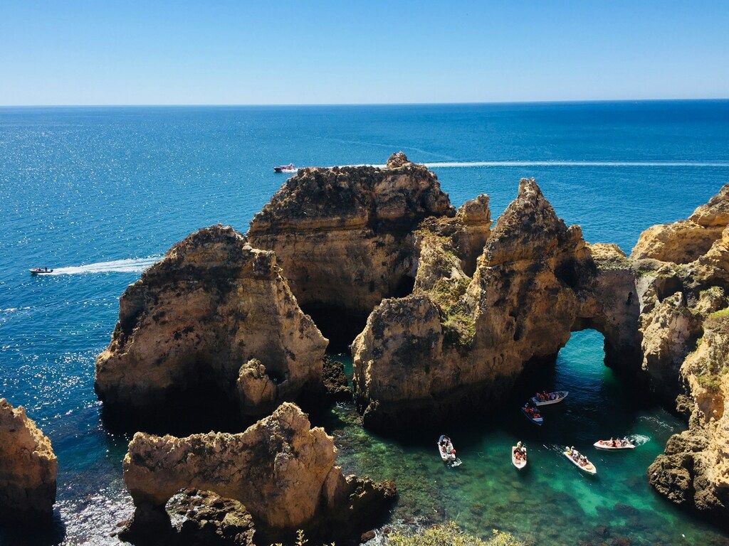 Petits bateaux naviguant entre les falaises spectaculaires de Ponta da Piedade à Lagos.