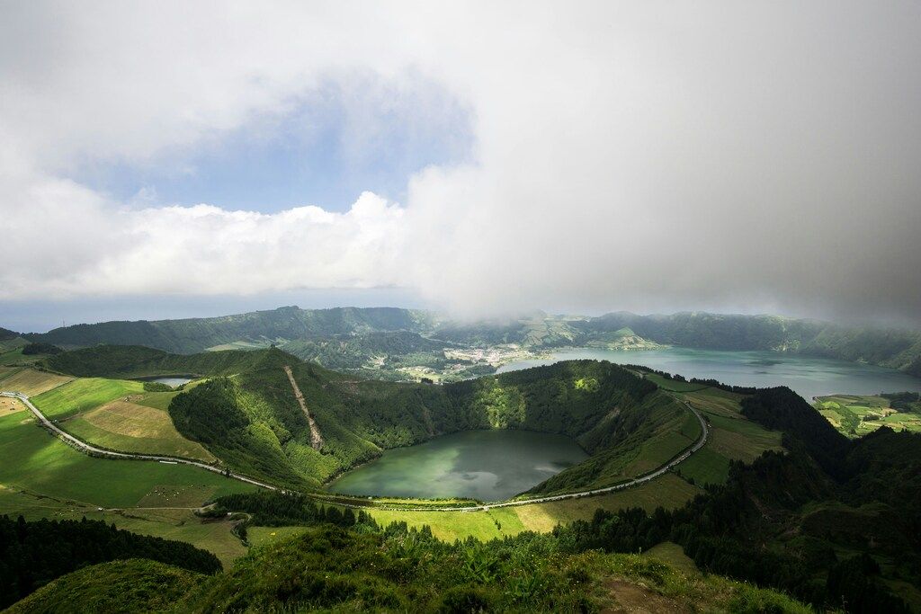 Vue aérienne de Sete Cidades, un lac volcanique emblématique des Açores entouré de verdure et de nuages bas