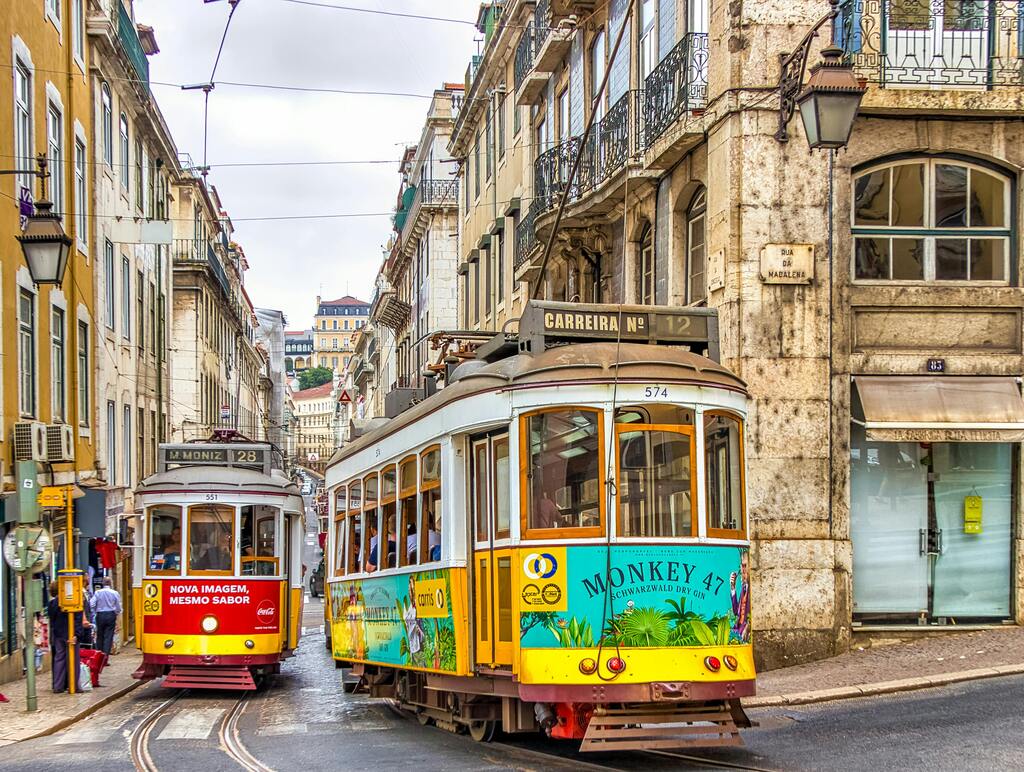 Tramways colorés traversant les rues étroites du centre historique de Lisbonne.