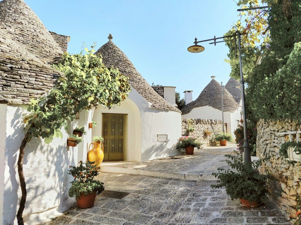 Ruelle bordée de trulli traditionnels aux toits coniques à Alberobello, dans les Pouilles.