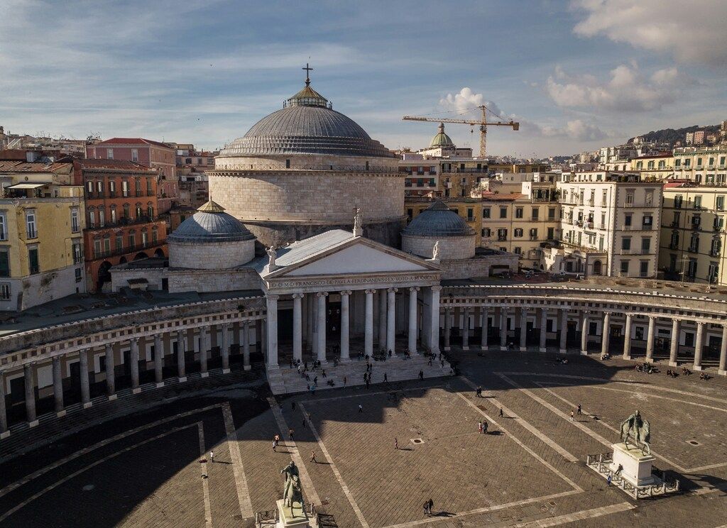 Vue aérienne de la Piazza del Plebiscito à Naples avec la basilique et les bâtiments environnants.