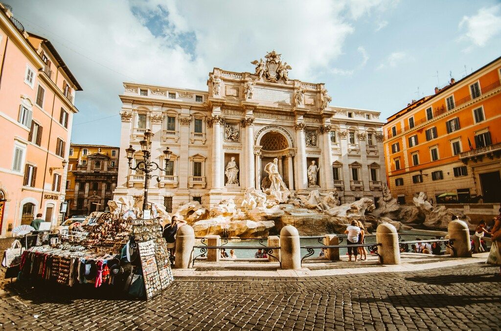 La célèbre fontaine de Trevi à Rome entourée de bâtiments colorés et de visiteurs.