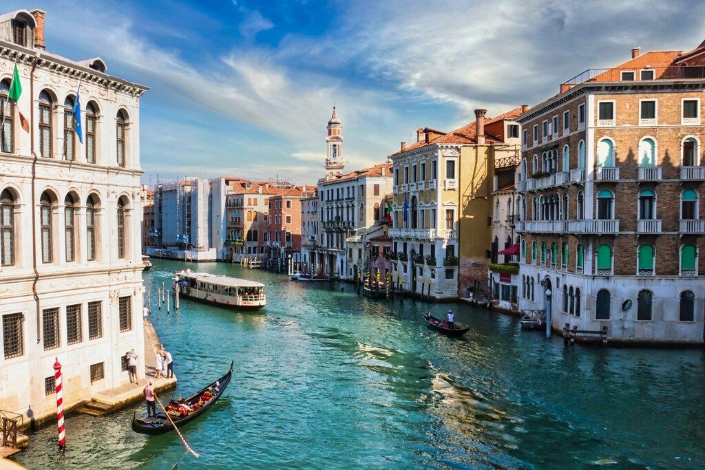 Vue pittoresque du Grand Canal à Venise avec des gondoles et des bâtiments historiques colorés.