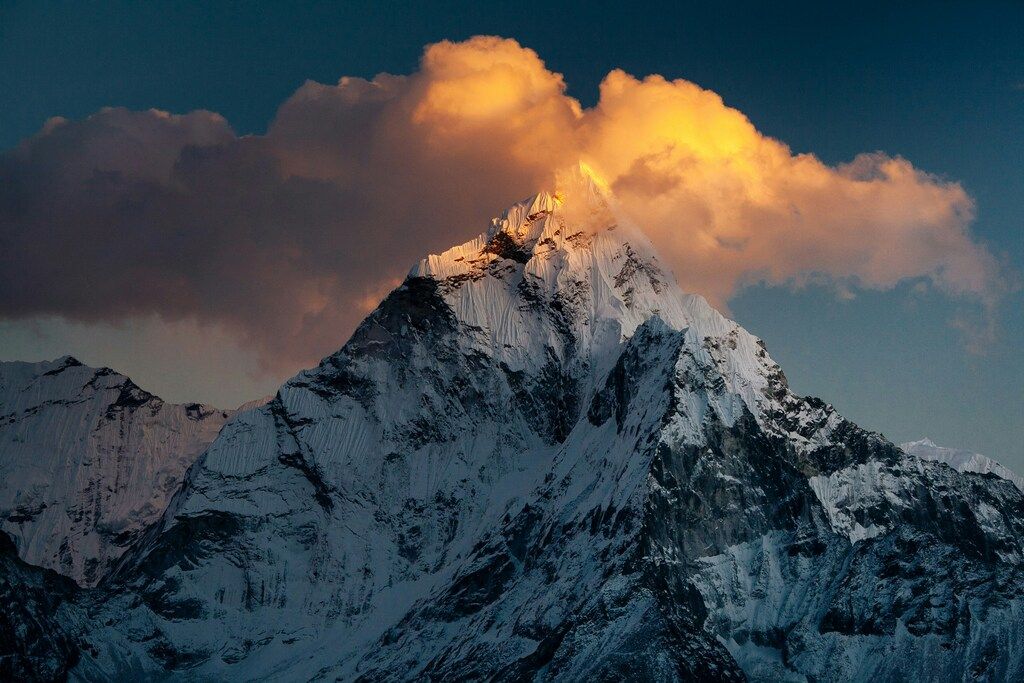 Cime himalayenne percée par un nuage doré au coucher du soleil, ambiance mystique.