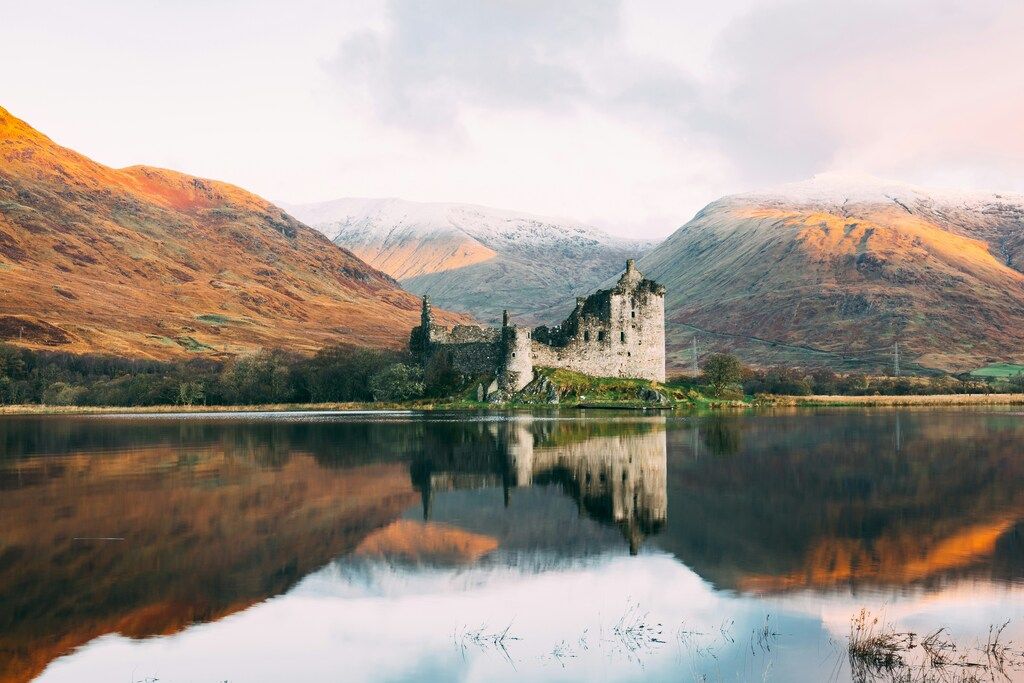 Ruines du château de Kilchurn reflétées dans les eaux calmes du loch écossais