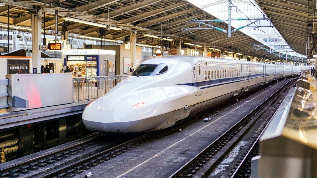 Train à grande vitesse Shinkansen à quai dans une gare moderne au Japon.