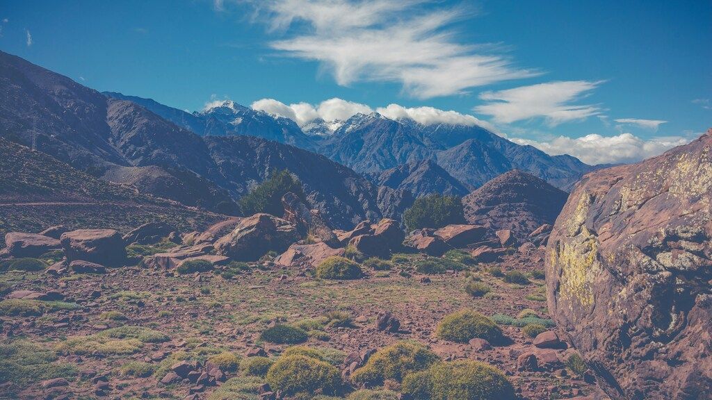 Vue panoramique des montagnes de l'Atlas avec des rochers rouges au premier plan