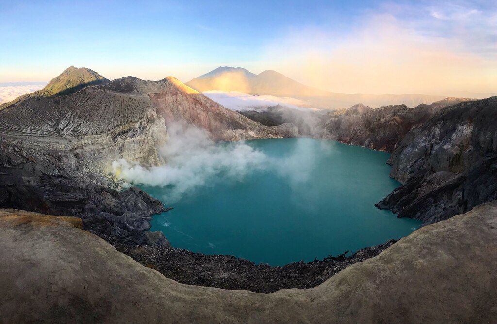 Vue spectaculaire sur le cratère du volcan Kawah Ijen avec son lac acide bleu turquoise et ses fumerolles de soufre.
