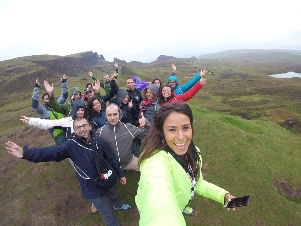 Groupe de voyageurs WeRoad souriant lors d'une randonnée en Écosse