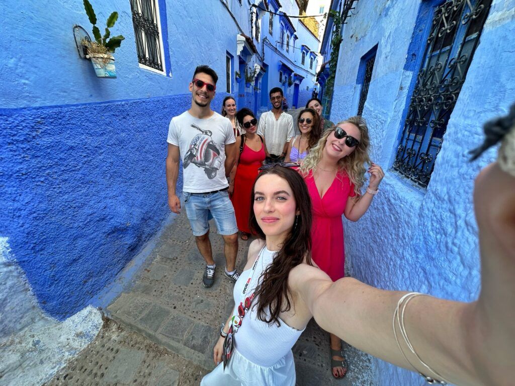 Selfie de groupe de voyageurs WeRoad dans les célèbres ruelles bleues de Chefchaouen.