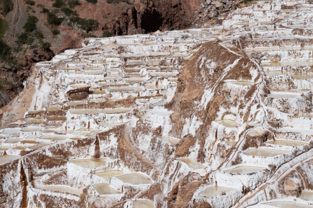 Vue aérienne des Salines de Maras au Pérou, montrant des milliers de bassins de sel rectangulaires et terrassés.