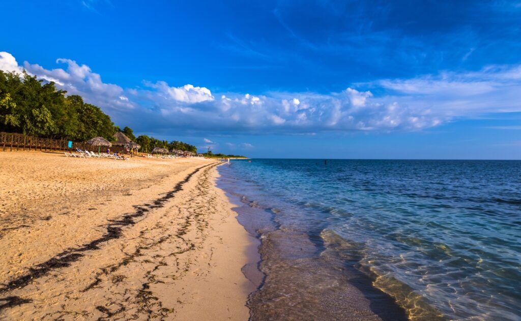 Vue au coucher du soleil de Playa Ancón : longue bande de sable doré et mer calme.