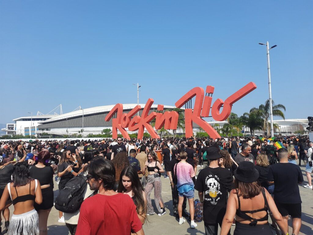 Une foule nombreuse rassemblée devant l'immense logo rouge "Rock in Rio" lors d'un festival de musique au Brésil.