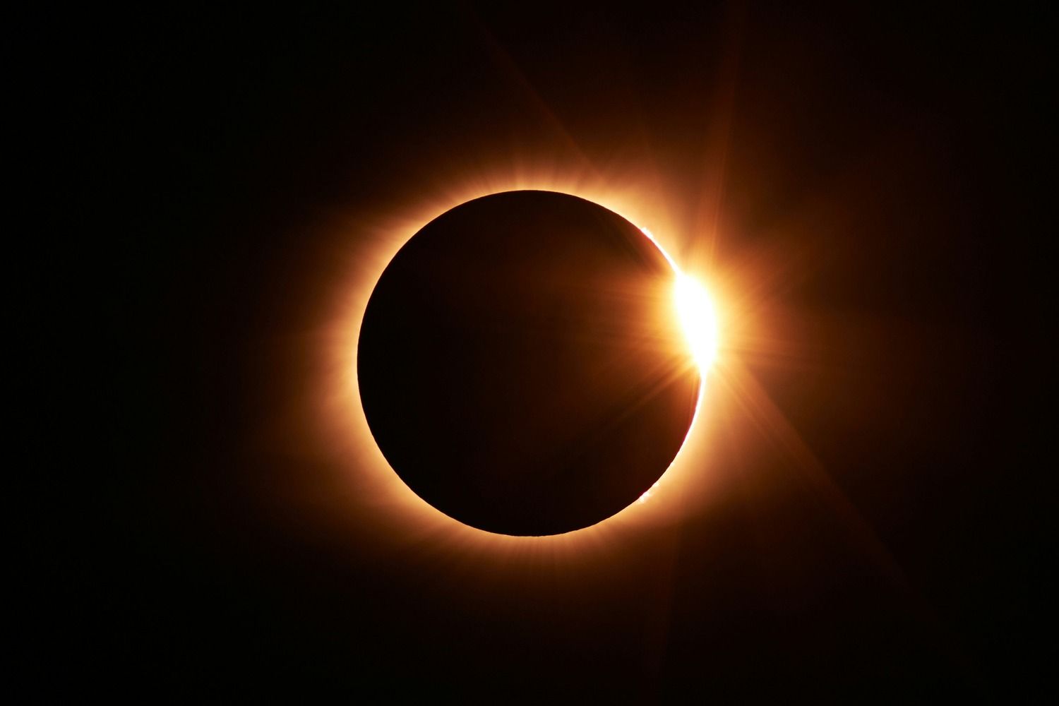 Éclipse solaire totale avec effet bague de diamant, couronne solaire lumineuse autour de la lune sur ciel noir