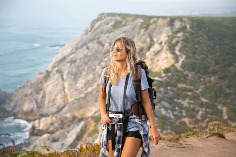 Voyageuse sur une falaise avec vue sur l ocean