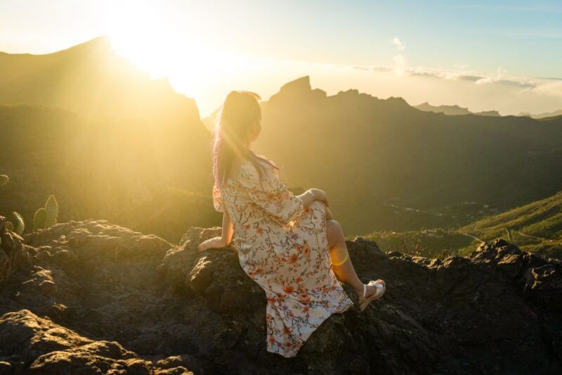 Une jeune fille, seule, admire le lever du soleil.