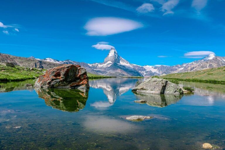 Le Cervin se reflète dans les eaux calmes du lac Stellisee, entouré de rochers, en Suisse