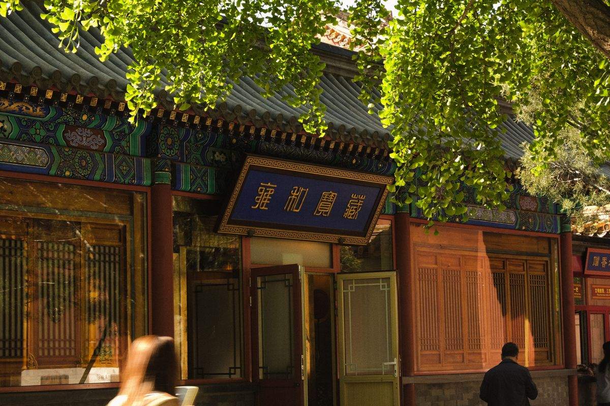 Façade d’architecture chinoise traditionnelle avec enseigne bleue et feuillage suspendu
