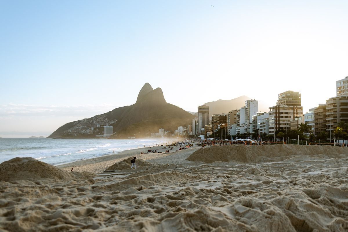 Plage d’Ipanema au soleil avec immeubles, sable et montagne en arrière-plan