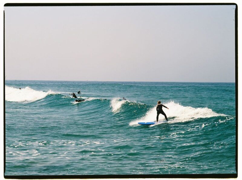Plusieurs surfeurs glissent sur des vagues sous un ciel dégagé. Plusieurs surfeurs glissent sur des vagues sous un ciel dégagé.