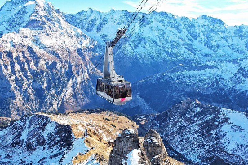 Télécabine suspendue survolant des montagnes enneigées dans les Alpes suisses