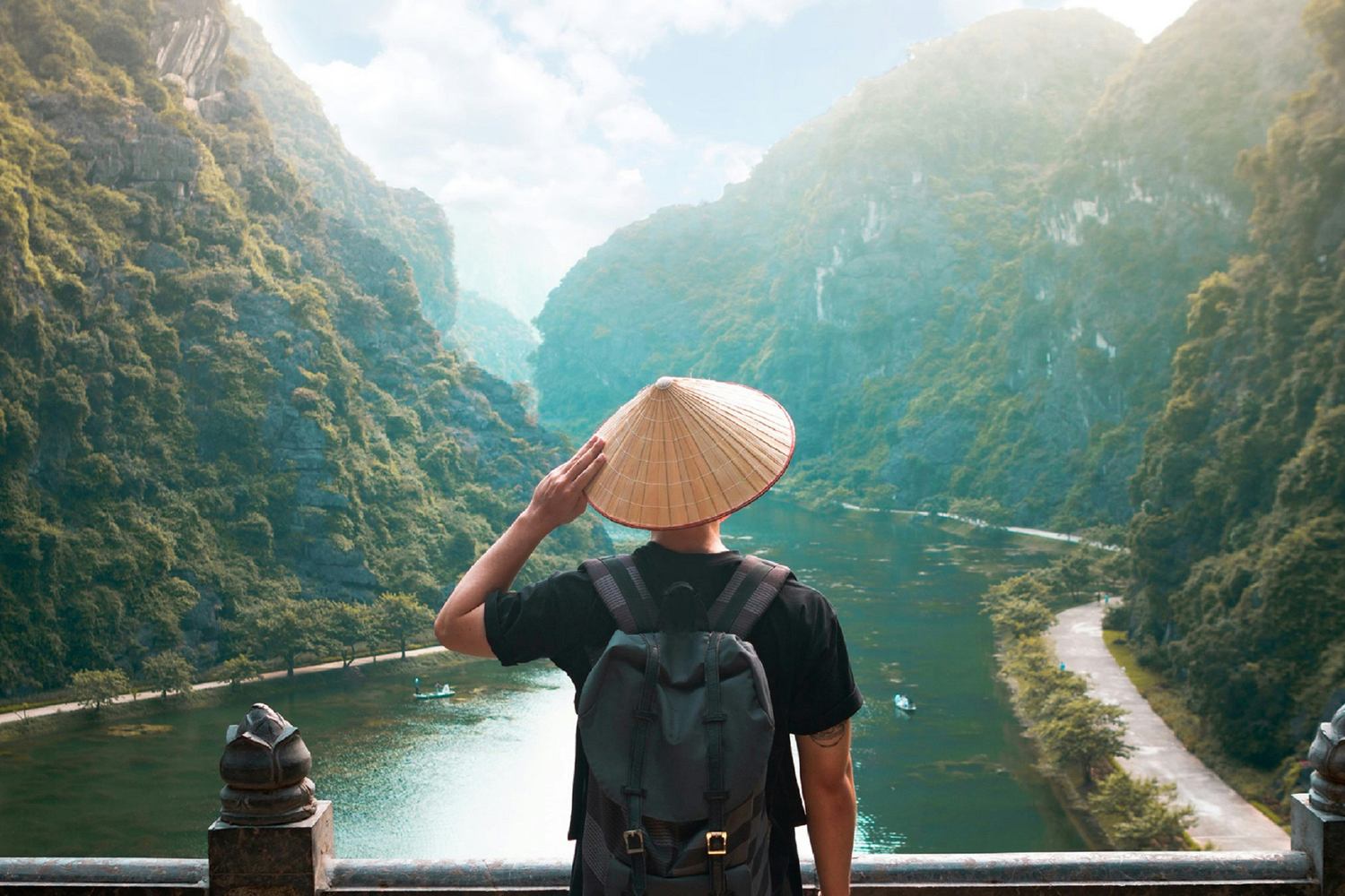 Voyageur de dos avec un chapeau conique vietnamien admirant la vallée karstique de Trang An, au Vietnam