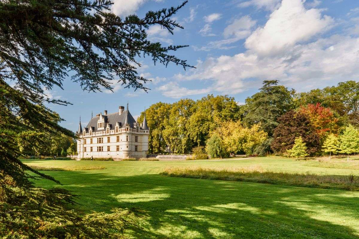 Château d’Azay-le-Rideau entouré d’une vaste pelouse et d’arbres sous un ciel dégagé
