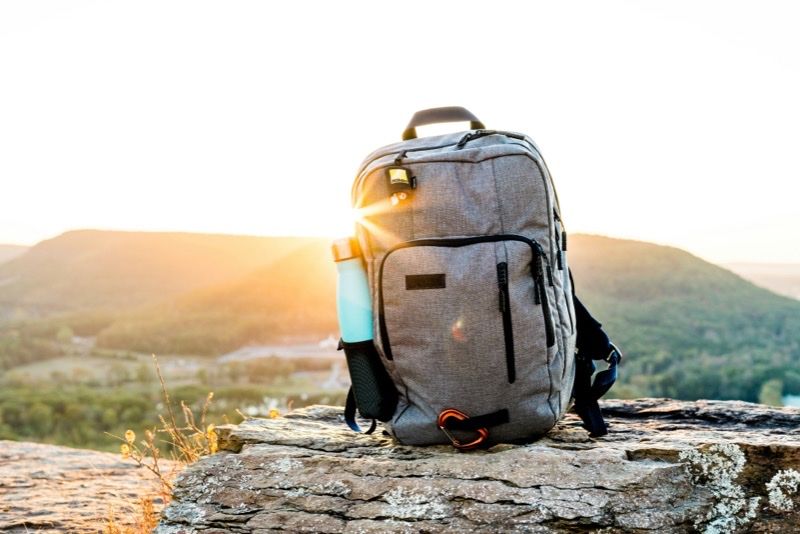 Sac a dos pose sur un rocher au lever du soleil