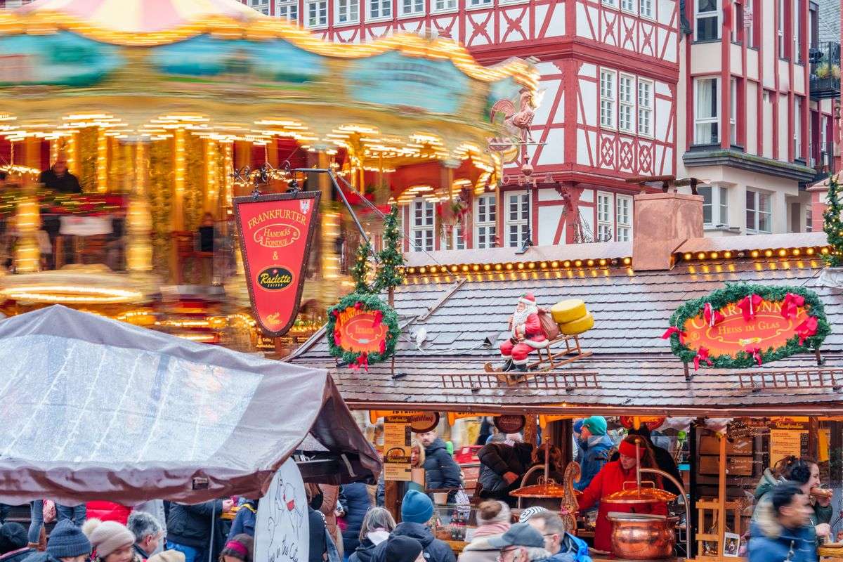 Carrousel lumineux et chalets de Noël animés sur une place de Francfort