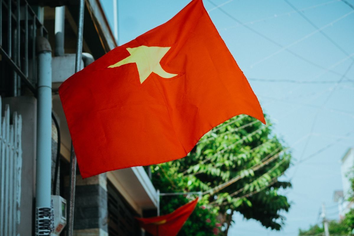 Drapeau du Vietnam rouge à étoile jaune accroché à un bâtiment en ville