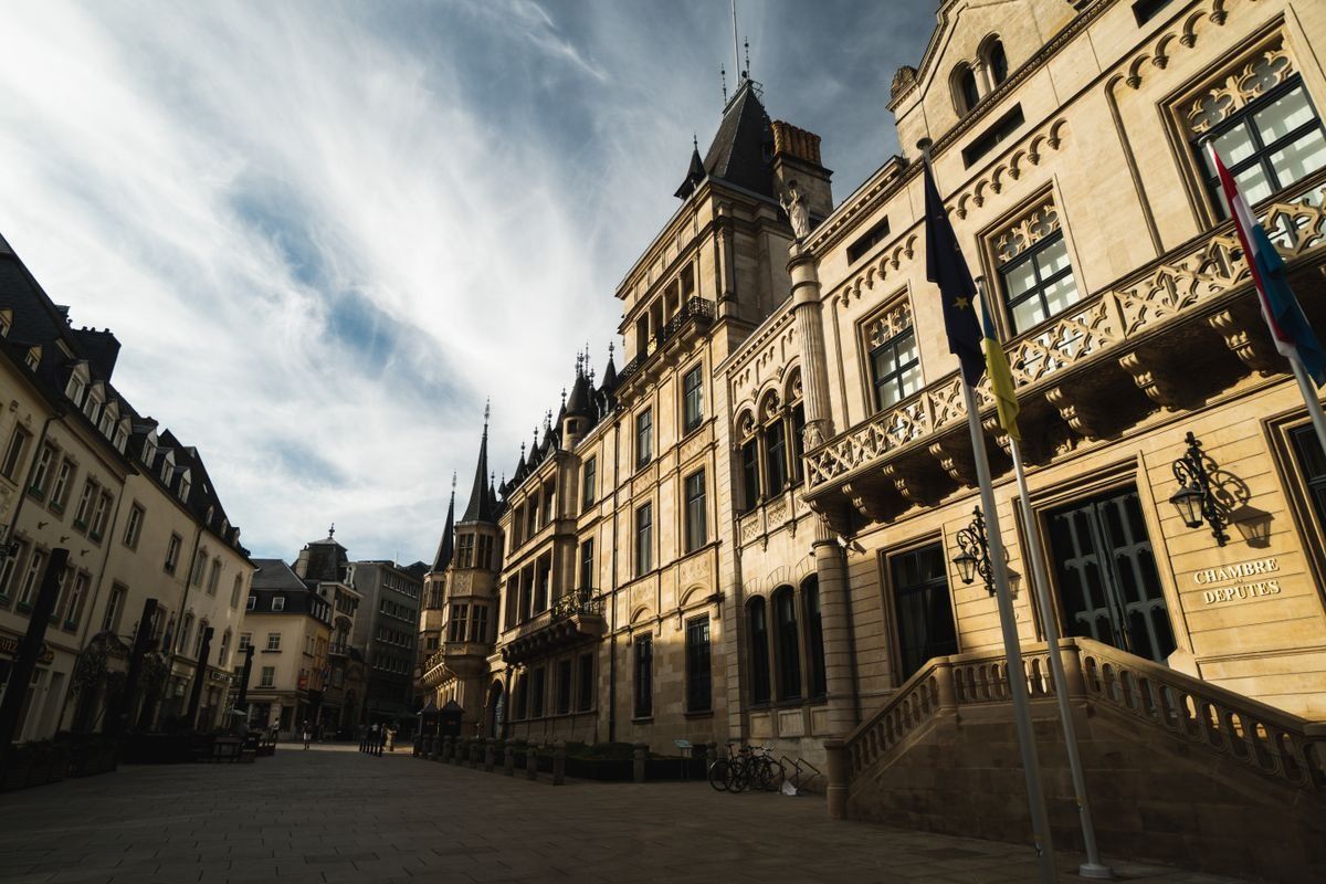 Façade du palais grand-ducal sur une place pavée sous un ciel nuageux