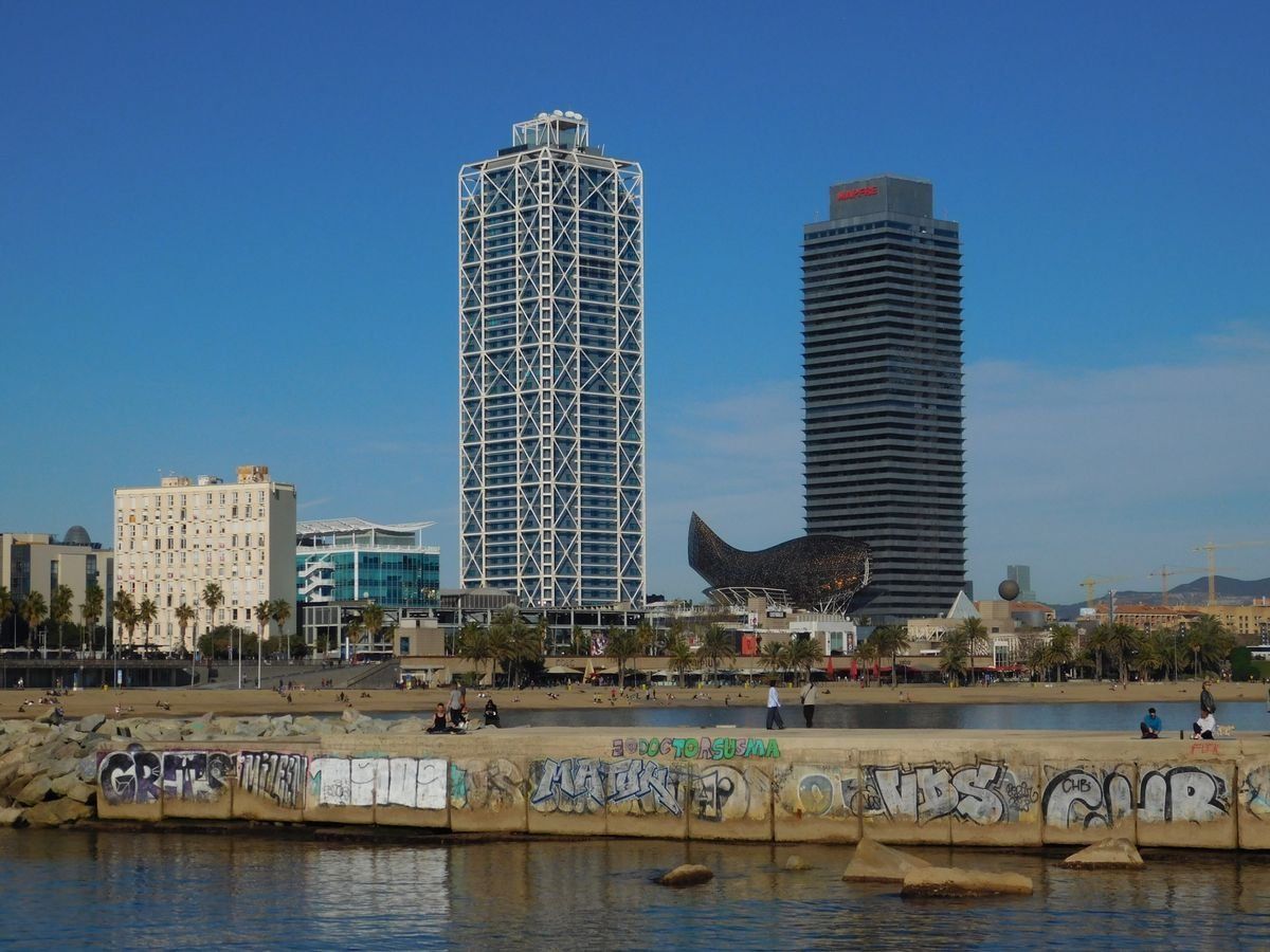 Front de mer de Barcelone avec immeubles modernes, digue en pierre et mer calme