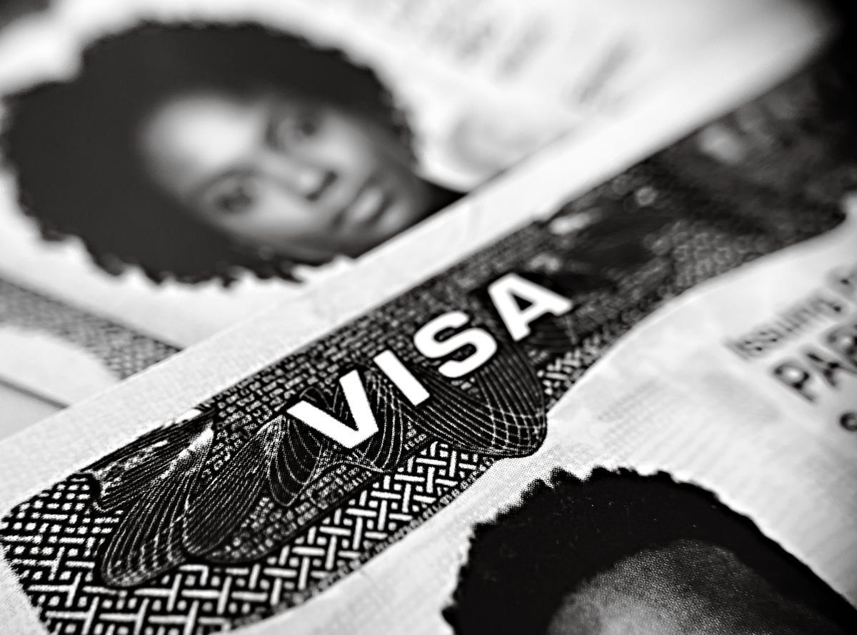 Gros plan en noir et blanc sur un document de visa avec portrait partiel