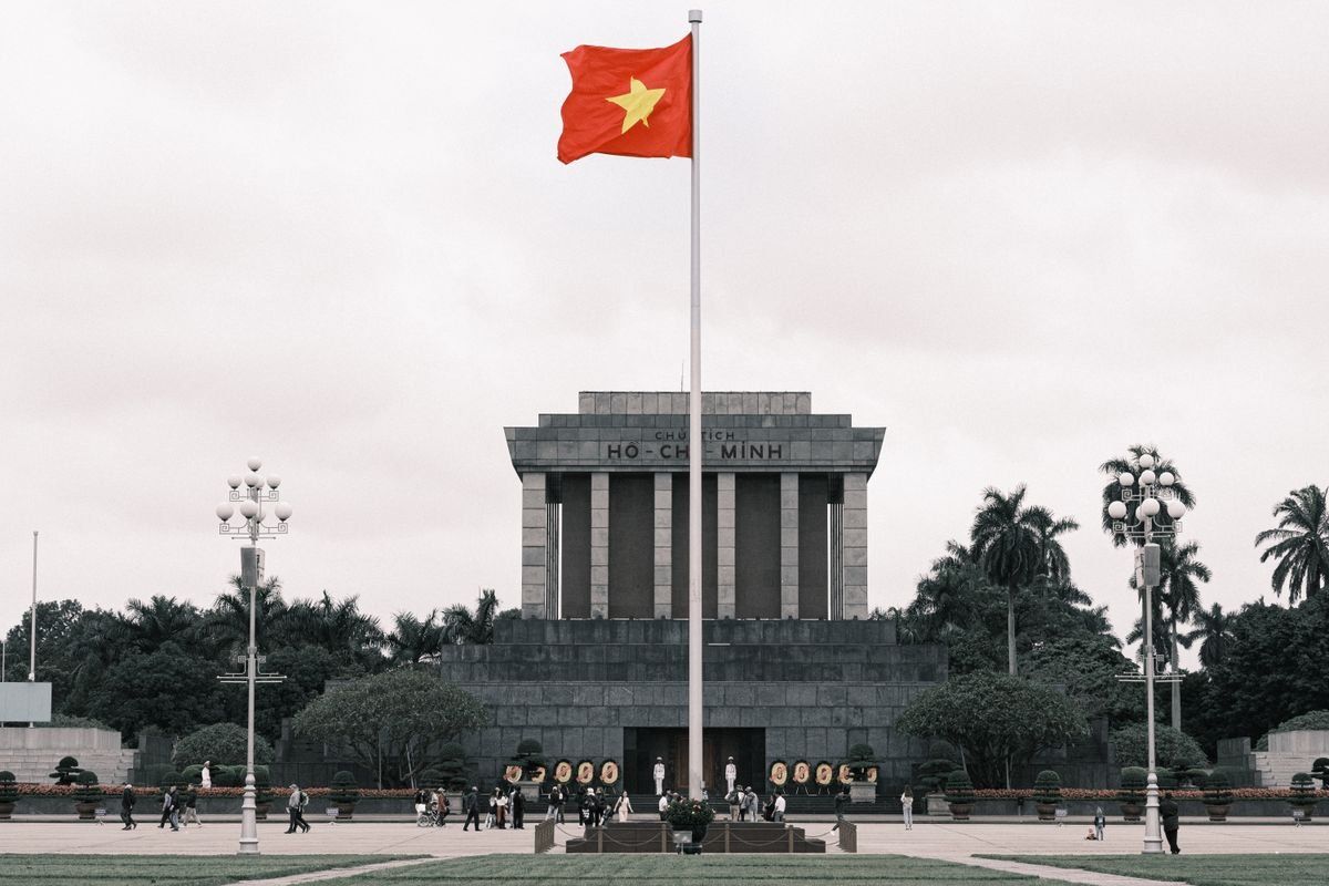 Mausolée de Hô Chi Minh à Hanoï avec drapeau vietnamien et passants