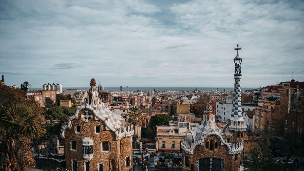 Pavillons du parc Güell et panorama urbain de Barcelone sous un ciel nuageux