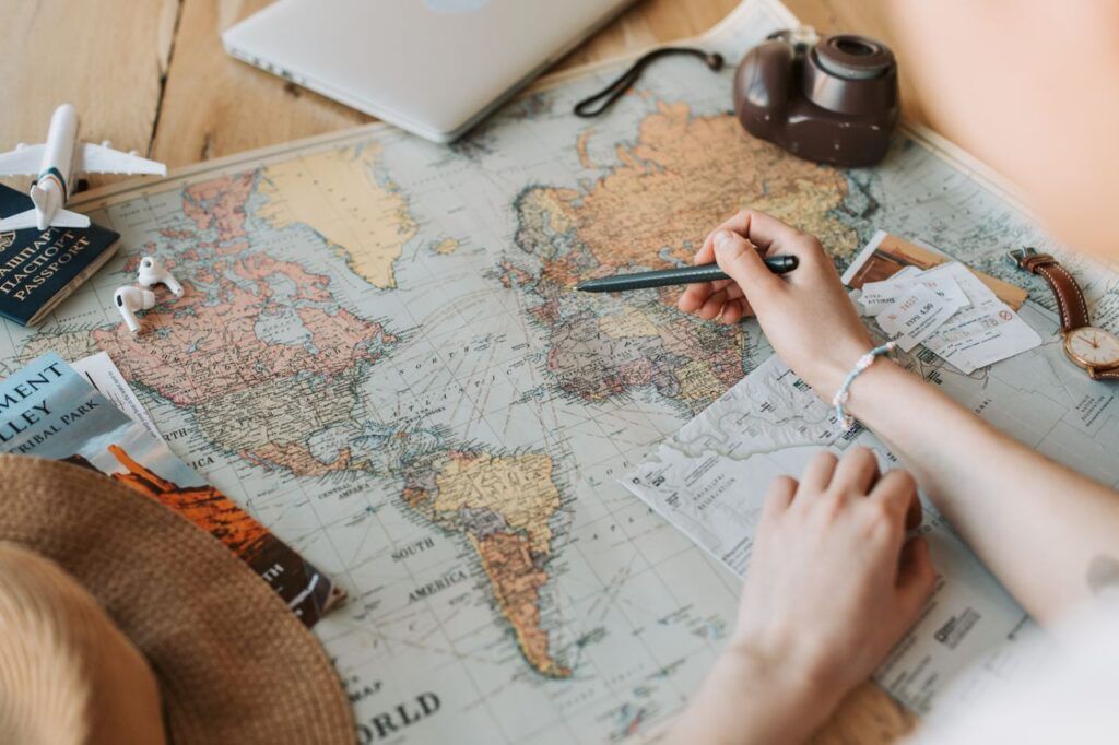 Mains marquant des destinations sur une carte du monde pour planifier un voyage