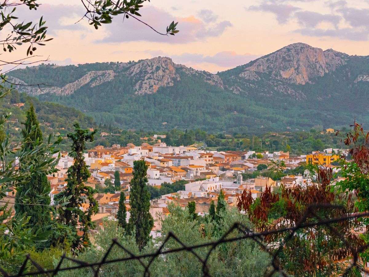 Village espagnol au coucher du soleil avec montagnes boisées en arrière-plan
